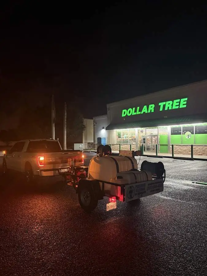Pressure washing trailer cleaning a retail parking lot at night in Rockledge, FL