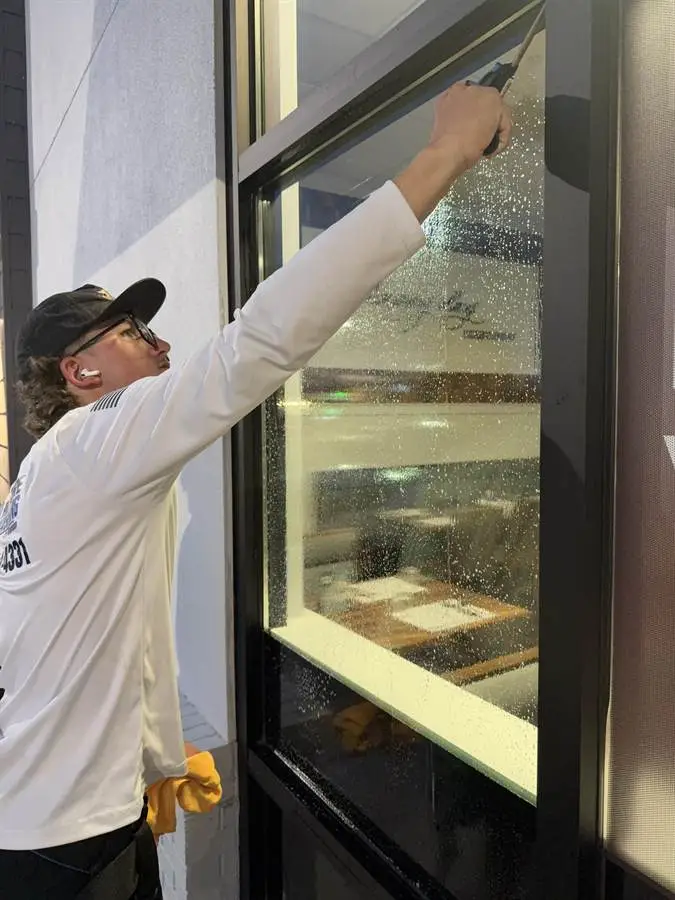 Technician squeegeeing commercial storefront glass in Rockledge, FL