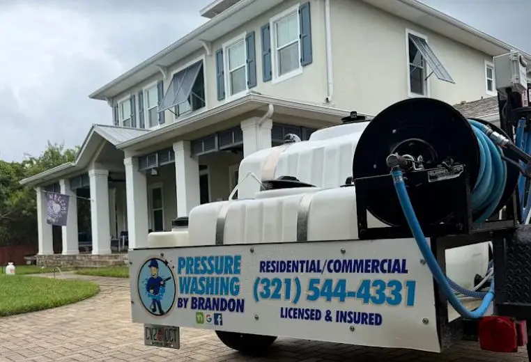 Pressure Washing by Brandon wash trailer outside a two-story home in Rockledge, FL