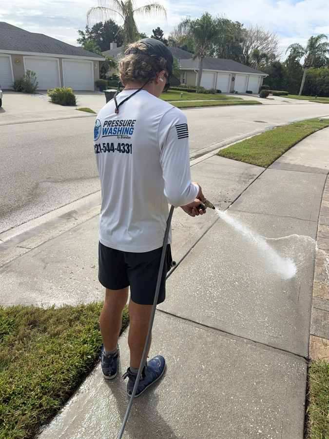 Technician rinsing a freshly cleaned sidewalk in Rockledge, FL
